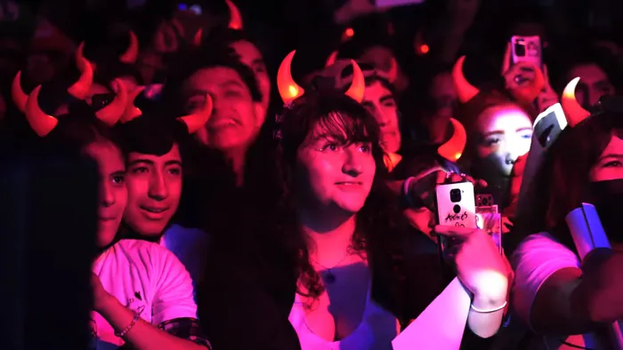 Fans con cuernitos bajo luz rosa