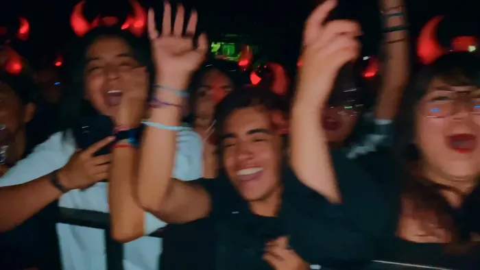 Fans con cuernitos rojos gritando en primera fila