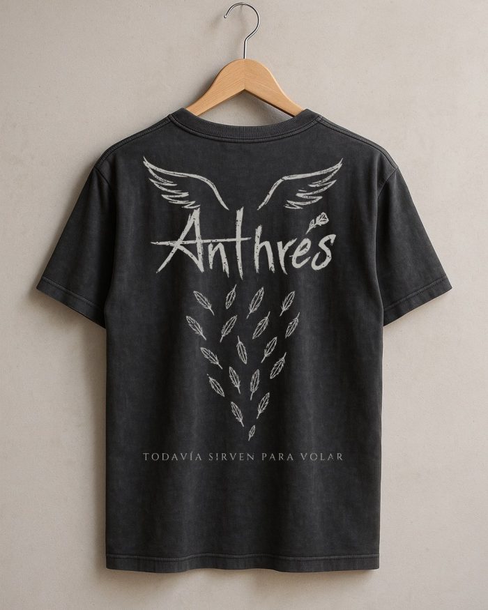 Playera negra de Anthrés: espalda con alas, plumas cayendo y la frase «Todavía sirven para volar»